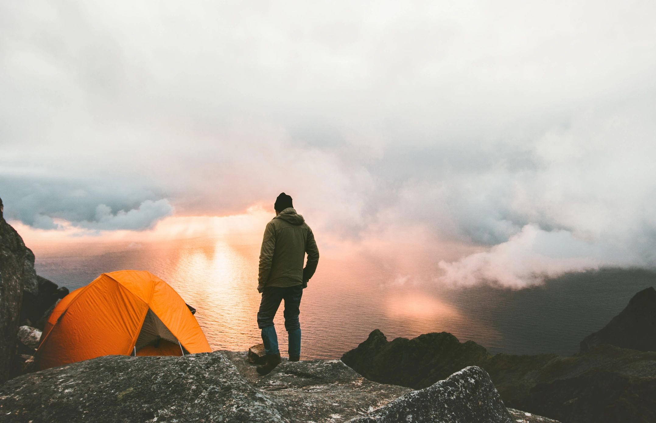 Man traveling with tent camping on mountain top